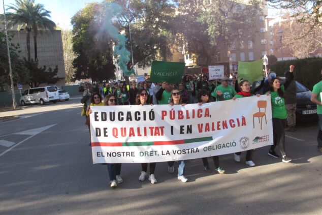 Manifestantes portan una pancarta que dice "Educació pública, de qualitat i en valencià" durante una protesta en Dénia.