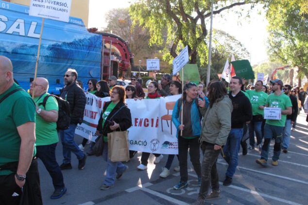 Manifestantes con camisetas verdes y pancartas durante una protesta por la educación pública en una calle de Denia.
