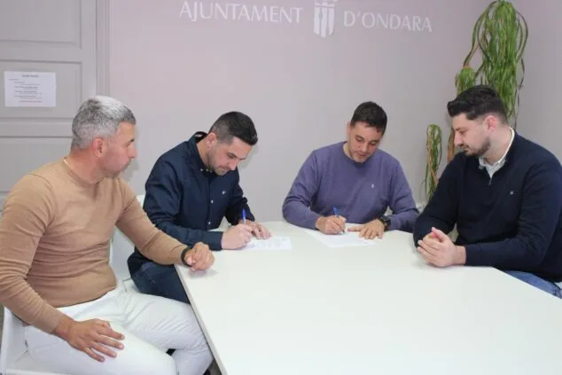 Imagen: Representantes del PSPV-PSOE y el PP de Ondara firmando documentos del acuerdo de inversiones en una mesa del Ayuntamiento.