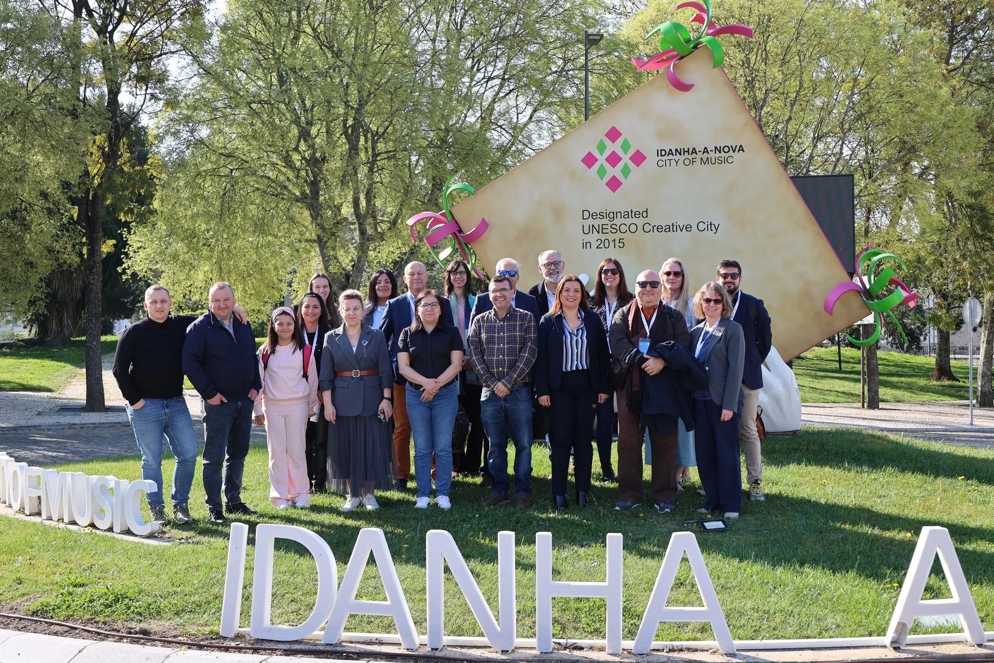 Grupo de participantes del proyecto europeo RE:START posando frente al cartel de "Idanha-a-Nova City of Music" en Portugal durante su primer encuentro.