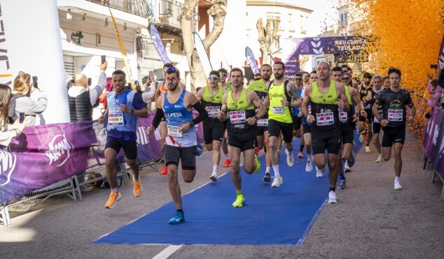 Imagen: Corredores en la salida de la XXII Volta Popular Teulada bajo una lluvia de confeti naranja.
