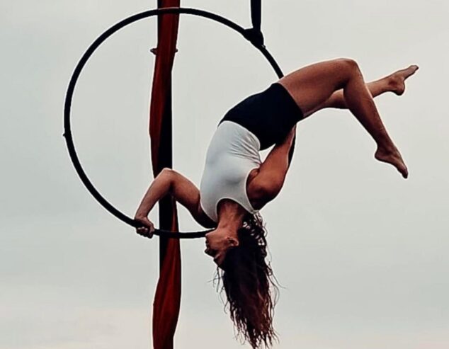 Imagen: Acróbata aérea de La Marina Social Club realizando una figura en un aro durante una competición.