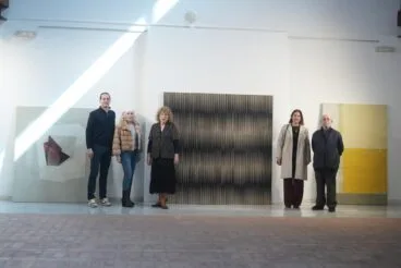 Miembros del jurado del 44º Certamen de Pintura S. Soria de Benissa posan frente a obras de arte en una galería.