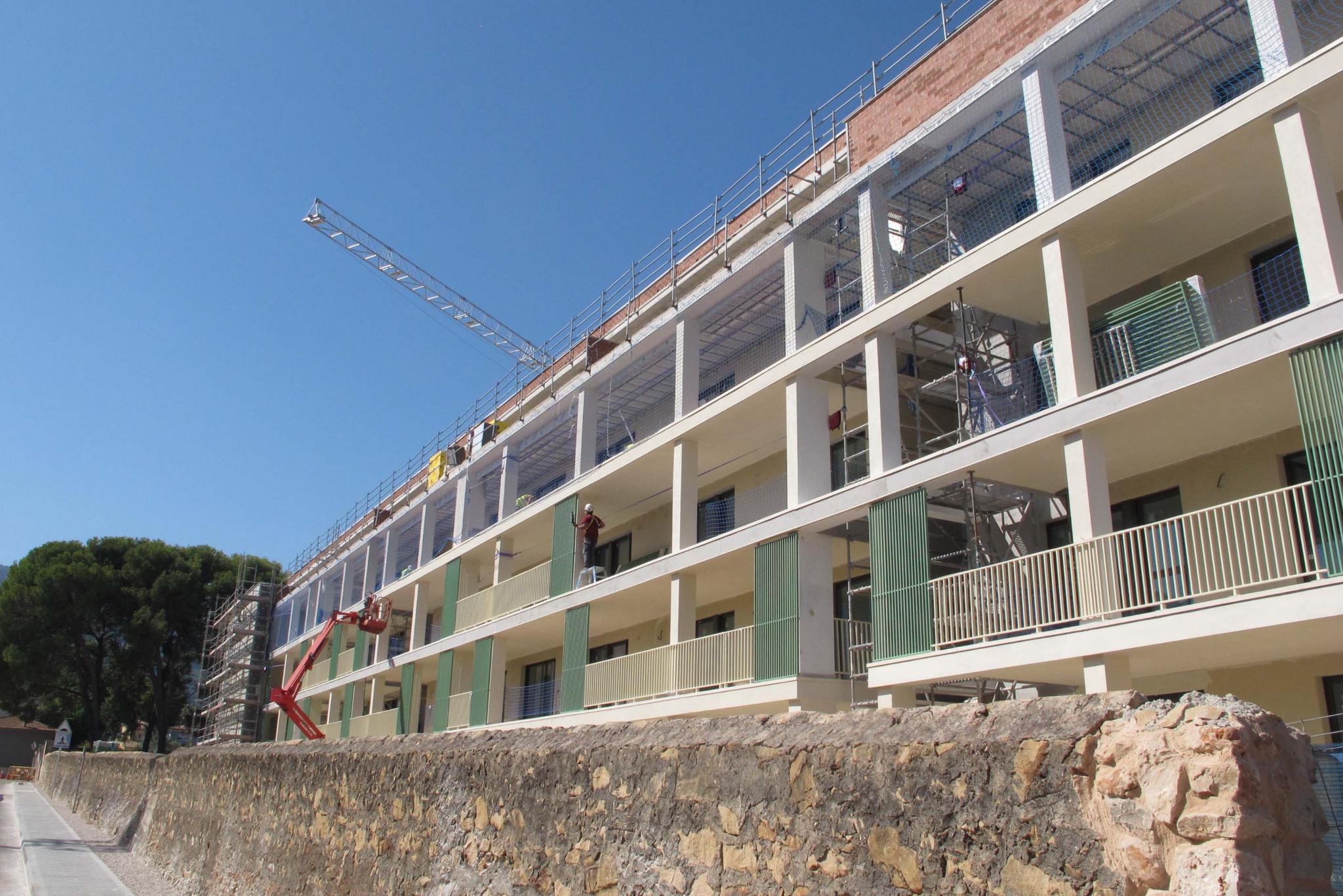 Edificio residencial en construcción con andamios y grúa torre en Dénia, Marina Alta