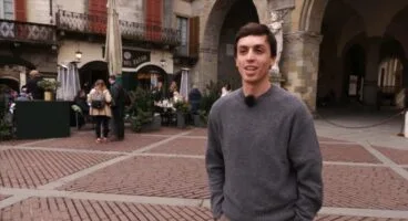 Un participante del programa Valencians al món con micrófono en una calle del norte de Italia