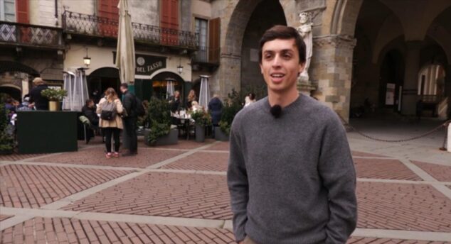 Un participante del programa Valencians al món con micrófono en una calle del norte de Italia