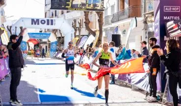 Ganadora femenina cruzando la meta y rompiendo la cinta en la XXII Cursa Teulada 2026.