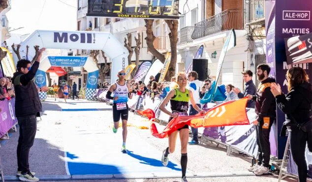 Ganadora femenina cruzando la meta y rompiendo la cinta en la XXII Cursa Teulada 2026.