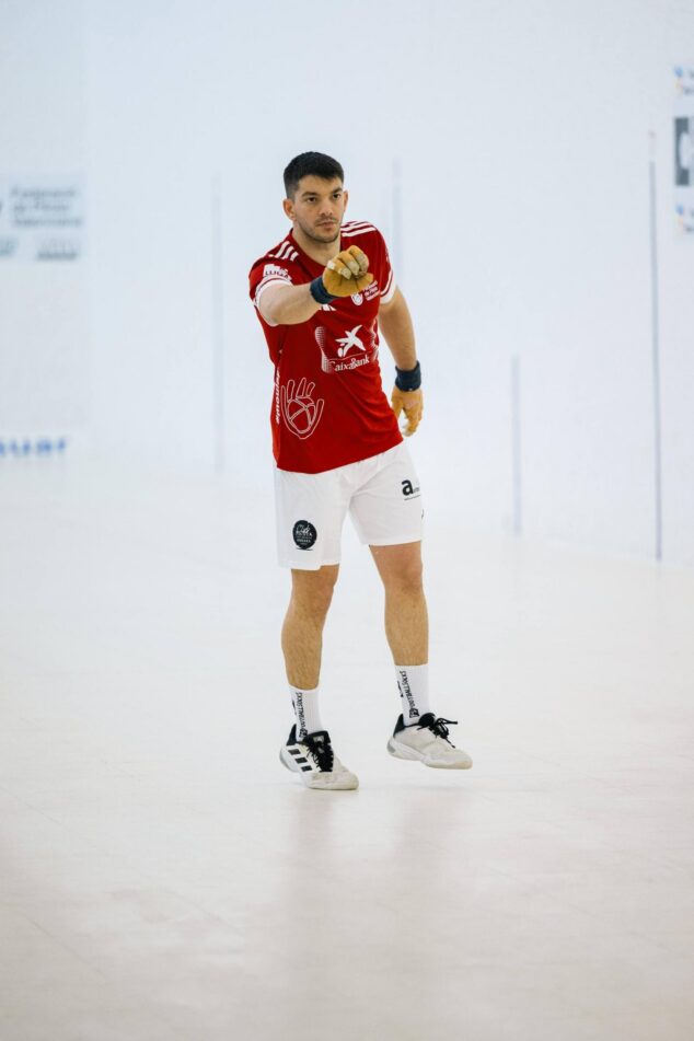 Los hermanos Terrades de Ondara hacen historia al conquistar la Liga CaixaBank de Raspall Pro2 15 Jugador del equipo de pilota valenciana de Ondara, uno de los hermanos Terrades, en el trinquet vistiendo la equipación roja de CaixaBank durante una partida de raspall.
