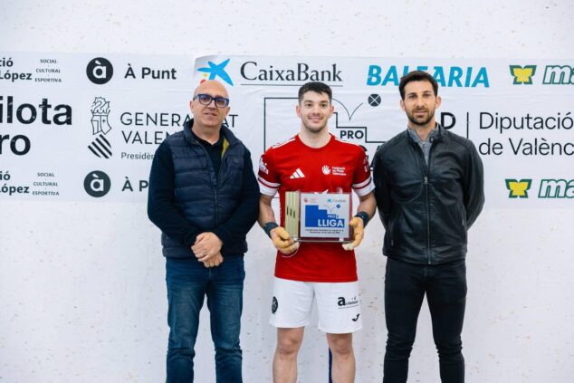 Los hermanos Terrades de Ondara hacen historia al conquistar la Liga CaixaBank de Raspall Pro2 9 Un jugador del equipo de Ondara sostiene el trofeo de campeón de la Liga CaixaBank de Raspall Pro2, acompañado por dos representantes institucionales frente a un banner de la competición.