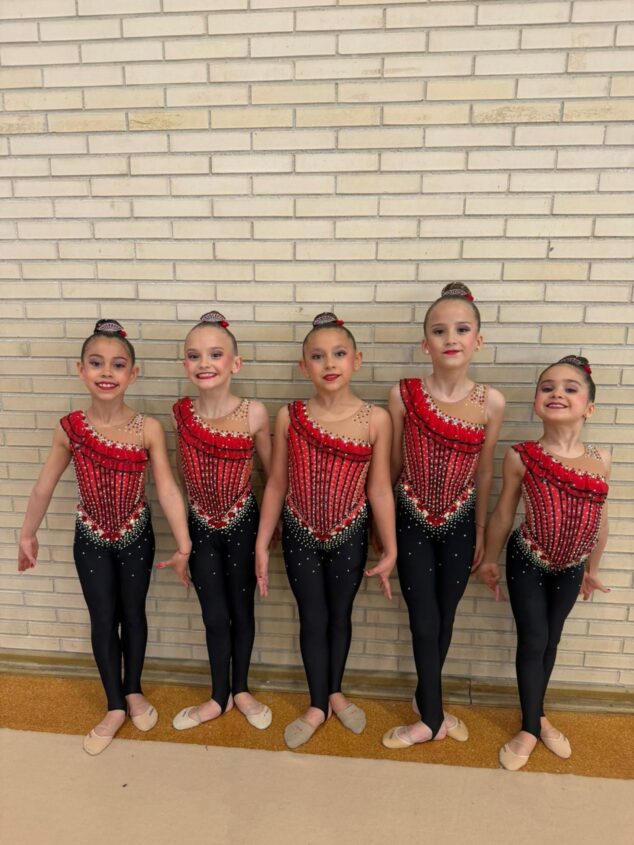 Imagen: Cinco gimnastas del Club Gimnasia Les Marines de Calp posan con maillots rojos y negros tras la competición provincial.