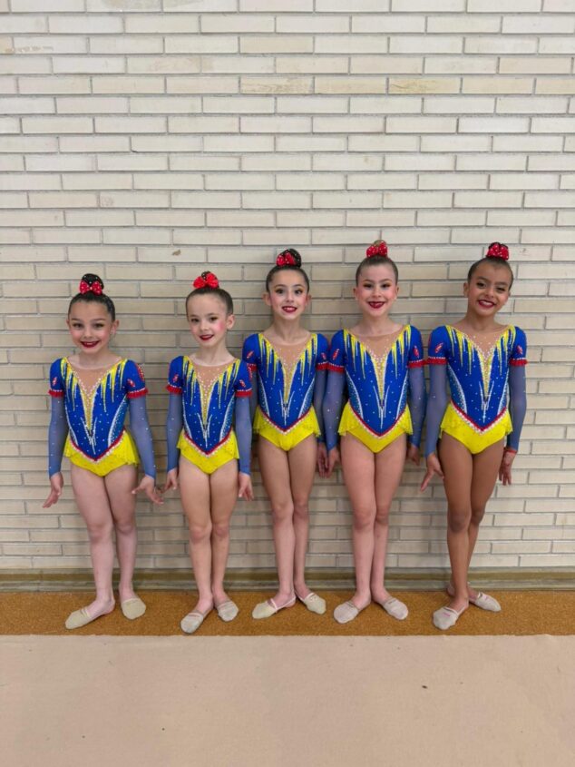 Imagen: Cinco gimnastas del conjunto del CG Les Marines de Calp posando con maillots de competición.