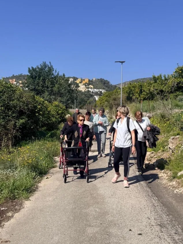 L'Atzúbia y Forna se unen a «Camina», el programa que combina actividad física y socialización 3 Imagen: Grupo de personas mayores, una de ellas con andador, caminando por una ruta rural acompañadas por una profesional sanitaria.