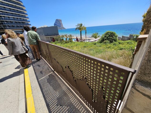 Personas observando la nueva barandilla artística de metal en Calp con el Peñón de Ifach al fondo.