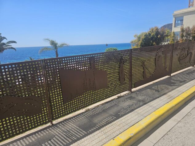 Barandilla metálica con diseños artísticos recortados instalada frente al mar en Calp.