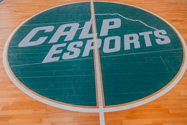 Imagen: Logotipo verde de Calp Esports con la silueta del Peñón de Ifach en el círculo central de una pista de baloncesto de madera.
