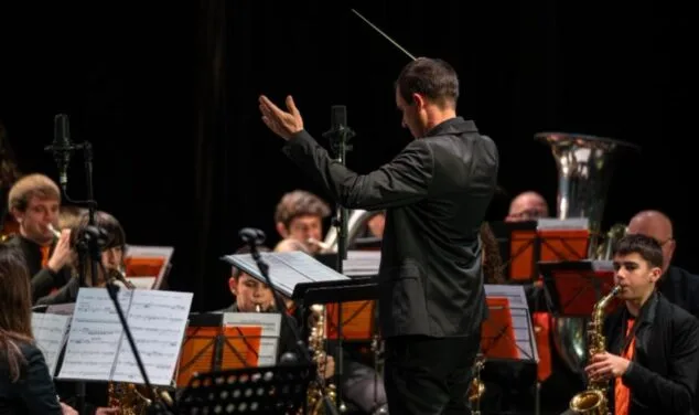 Imatge: El director Raúl Mínguez, d?esquena, dirigeix ​​amb la batuta els músics de l?Agrupació Musical CLAUdeFA–CALP.
