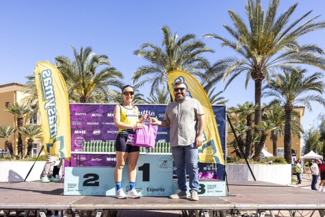 Cristina Roselló en el podio recibiendo un premio de un organizador durante la XVIII Volta a Peu El Verger.