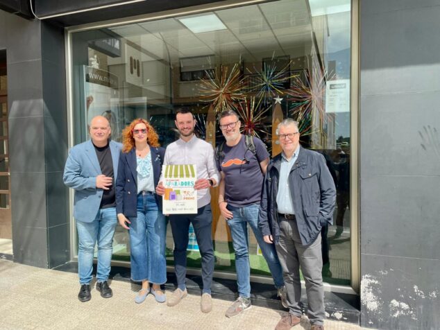Cinco personas posan frente al escaparate de Milar Giner con el diploma del tercer premio del concurso de escaparates de Benissa.