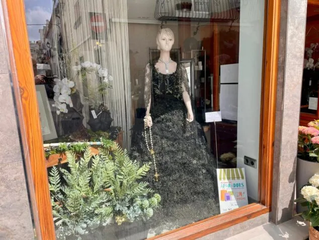 Los comercios de Benissa sorprenden con sus escaparates: estos son los ganadores de las fiestas patronales 3 Imagen: Escaparate decorado de Floristería Isabel mostrando el cartel del segundo premio del concurso.