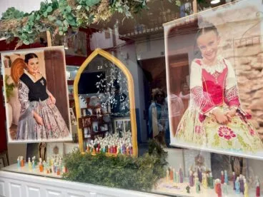 Escaparate de la tienda Foto Estudi Campos con decoración festiva y fotografías.
