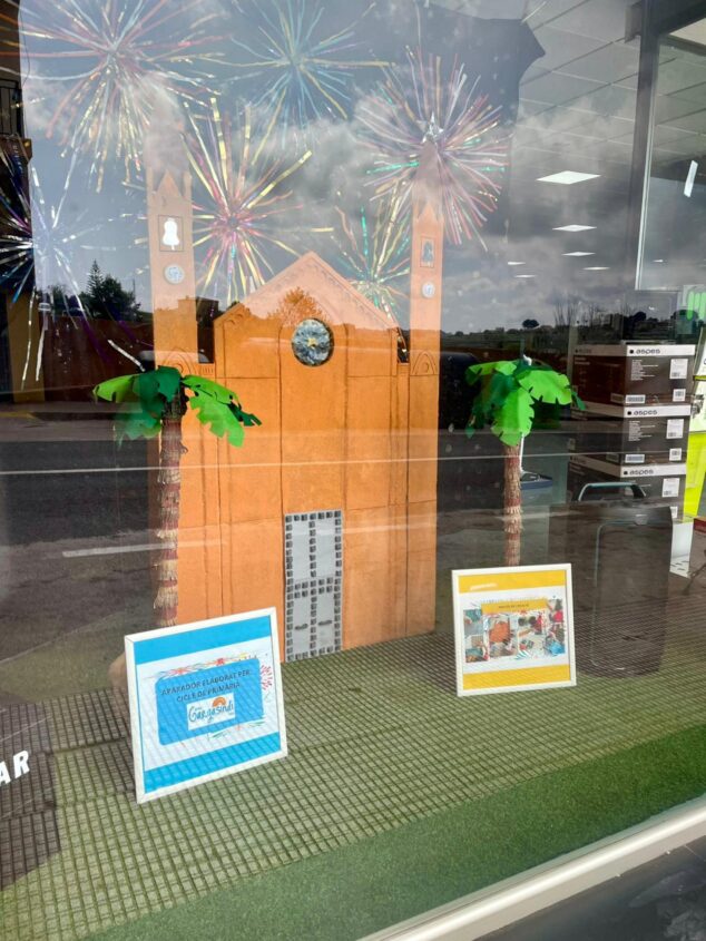 Imagen: Escaparate de la tienda Milar Giner decorado con una iglesia y palmeras de cartón.