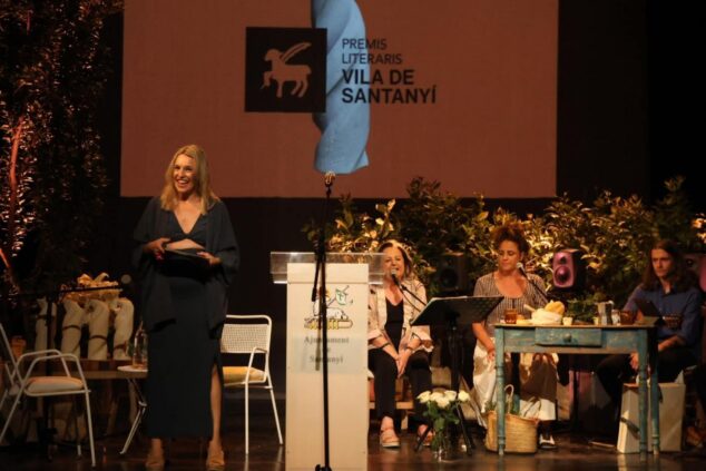 Imagen: Escenario de la gala de los Premis Literaris Vila de Santanyí con una oradora y músicos.