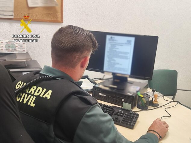 Imagen: Agente de la Guardia Civil de espaldas frente a un ordenador consultando información.