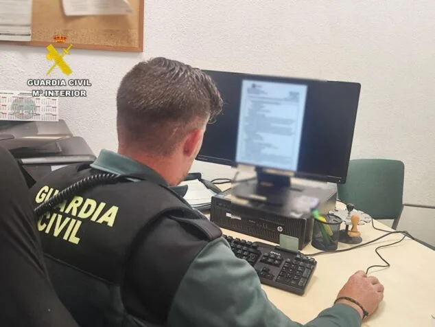 Imagen: Agente de la Guardia Civil de espaldas frente a un ordenador consultando información.
