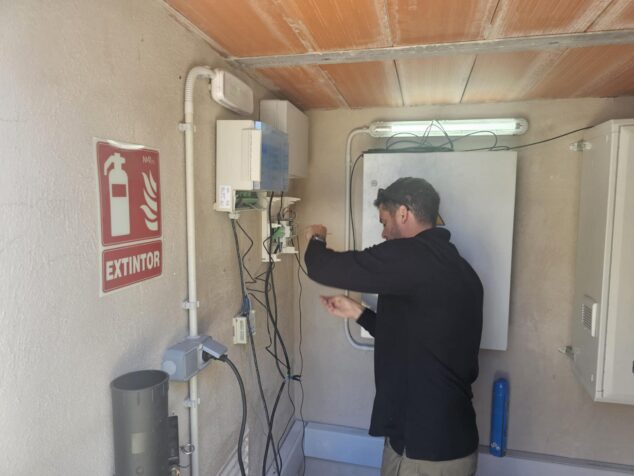 Técnico instalando componentes electrónicos del sistema de riego inteligente en una caseta en Calp.