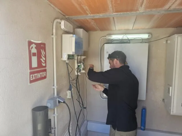 Imagen: Técnico instalando componentes electrónicos del sistema de riego inteligente en una caseta en Calp.