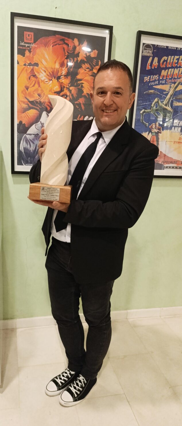 Imagen: Jovi Lozano-Seser sostiene el trofeo y la placa del Premio Antoni Vidal Ferrando de narrativa.