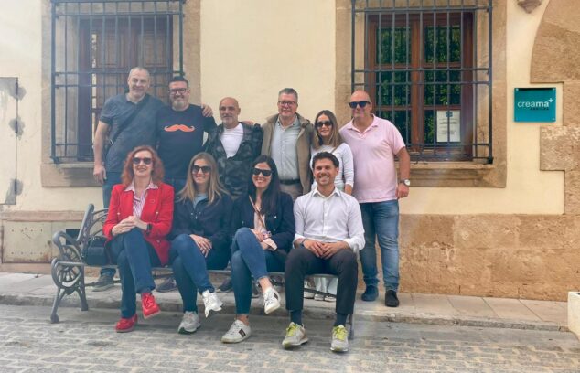 Imagen: Grupo de personas que conforman el jurado del concurso de escaparates de Benissa sentados y de pie frente a un edificio.