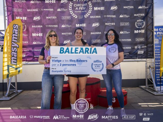 Imagen: Neus Fornés Masanet sostiene un cheque gigante de Baleària en el podio de la carrera.