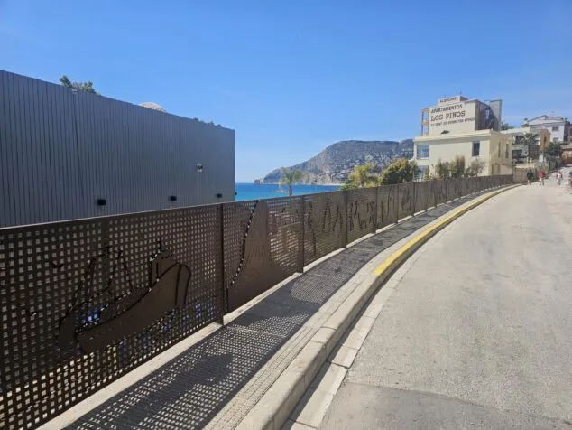La nueva barandilla artística de Toni Marí, un homenaje a las fiestas y símbolos de Calp 4 Vista de la nueva barandilla artística de hierro creada por Toni Marí en una calle de Calp, con vistas al mar y al Peñón de Ifach al fondo.