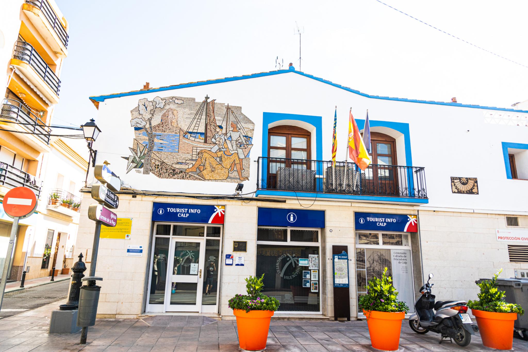 Exterior de la oficina Tourist Info Calp con un mural de mosaico en la fachada.