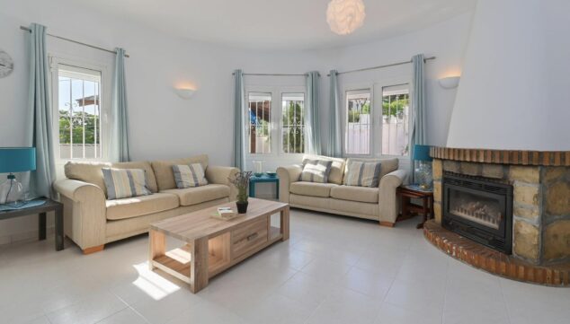 Casa Charlotte: una villa moderna cerca del mar en Benissa 2 salon confortable con chimenea y television para relajarse en invierno