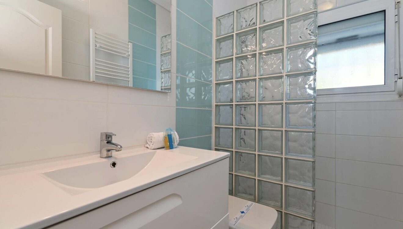 Segundo baño funcional con plato de ducha y acabados modernos
