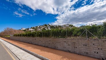 Restricción hasta nuevo aviso del consumo de agua en Monte Pego tras la avería 2 Vista exterior de la urbanización Monte Pego, con casas blancas escalonadas en una colina bajo un cielo con nubes.
