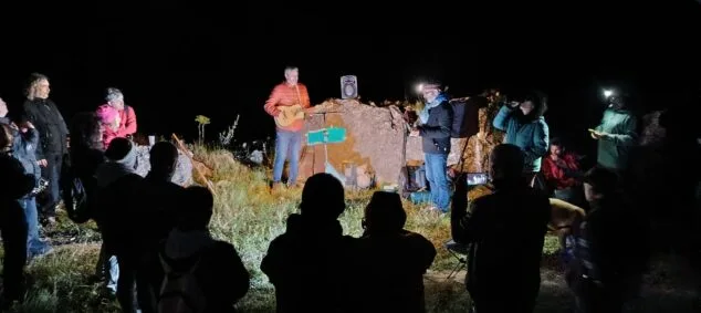 Imatge: Actuació musical nocturna a l'aire lliure a l'entorn del castell de Benissili amb públic assistent i il·luminada amb focus.