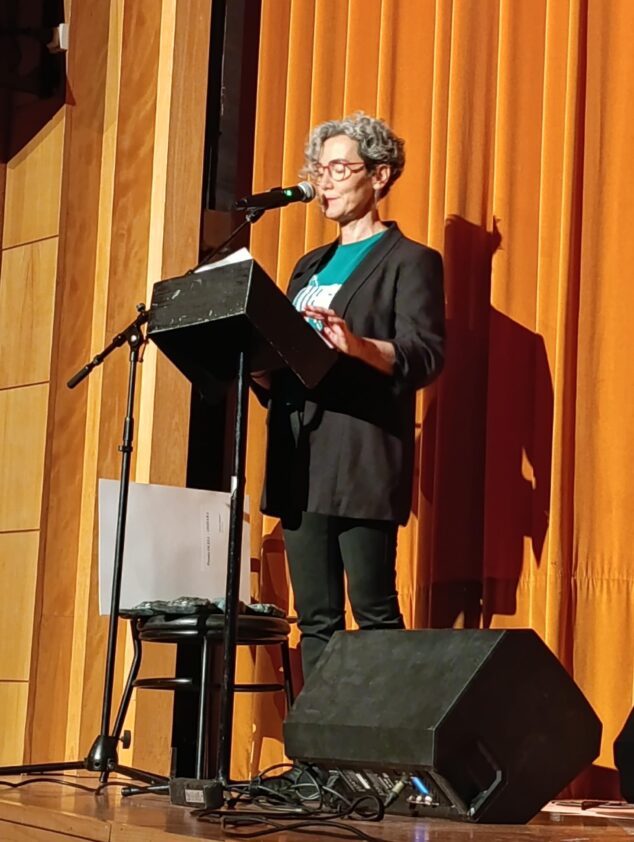 Imagen: Anna Mestre hablando desde un atril en el escenario durante la gala Premis Ocell de Ondara.