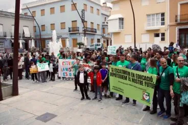 Fotografía de una concentración de personas en una plaza de Pego con pancartas en defensa de la educación pública.
