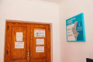 Fachada exterior y puerta de madera de acceso al consultorio médico de Tormos.