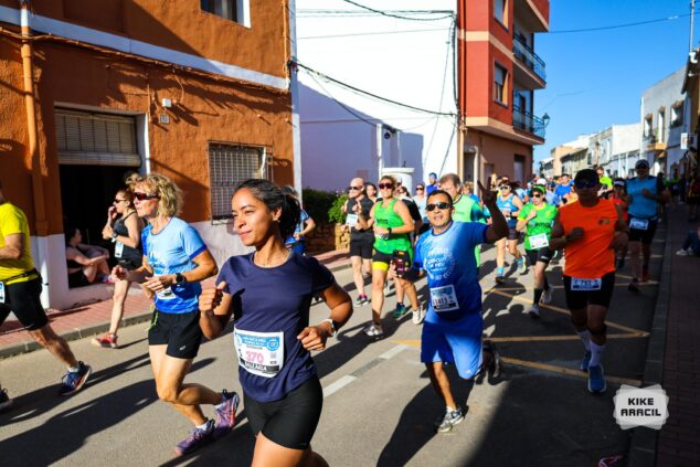 Imagen: Corredores durante una carrera popular por una calle estrecha.