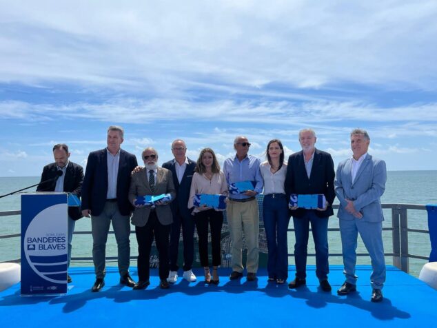 Imagen: Grupo de autoridades y premiados posando en un escenario al aire libre durante la entrega de Banderas Azules.