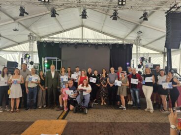 Foto de grupo con autoridades y empresarios sosteniendo certificados 'Somos Turismo Accesible' en un escenario en Calp.