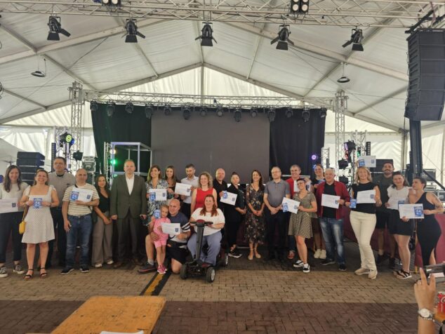 Cincuenta negocios de Calp reciben el distintivo 'Somos Turismo Accesible' 1 Imagen: Foto de grupo con autoridades y empresarios sosteniendo certificados 'Somos Turismo Accesible' en un escenario en Calp.