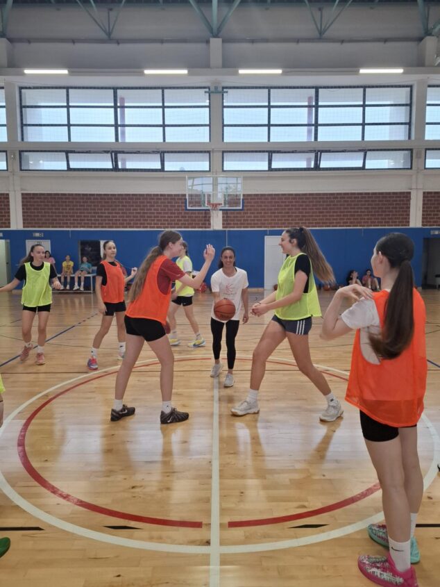 Varias chicas jóvenes juegan al baloncesto en un pabellón deportivo durante una sesión de entrenamiento del proyecto europeo EQUALPLAY en Croacia.