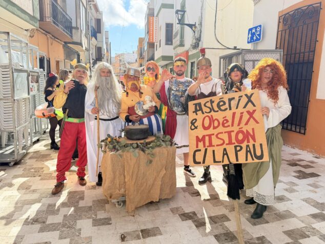 Imagen: Varios integrantes del grupo ganador disfrazados de personajes de Astérix y Obélix posan con un cartel sobre una misión en la calle La Pau.