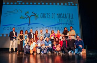Foto de grupo de los premiados y organizadores del festival Curts de Moscatell sobre un escenario.